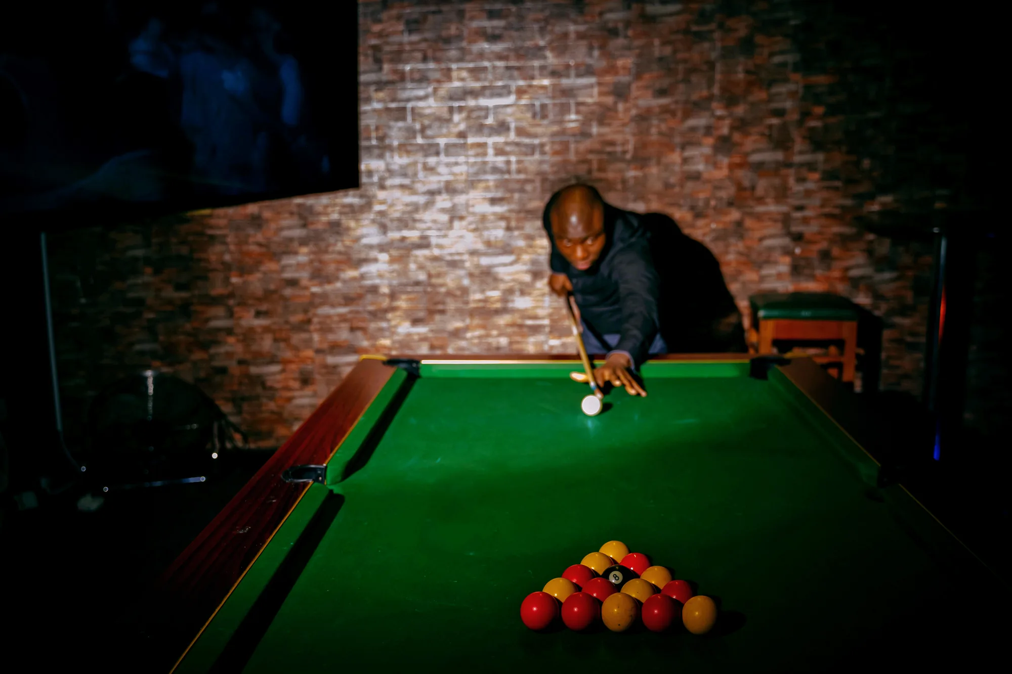 A player lining up a shot on the pool table